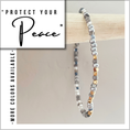 Load image into Gallery viewer, Beaded bracelet on a stick with 'Protect Your Peace' text and color availability note.