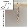 Load image into Gallery viewer, Beaded bracelet with gold and clear beads on a wooden stick, 'Sober AF' branding visible.