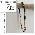 Load image into Gallery viewer, Beaded bracelet with black and gold beads on a gray background, with text overlay.