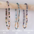 Load image into Gallery viewer, Three beaded necklaces labeled 'Stonecrop Mix', 'Gulf Shores Mix', and 'Blackberry Mix' on a wooden stick.