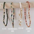 Load image into Gallery viewer, Four beaded bracelets labeled 'Olive', 'Everglades Mix', 'Cream', and 'Copper Mix' on a wooden stick.